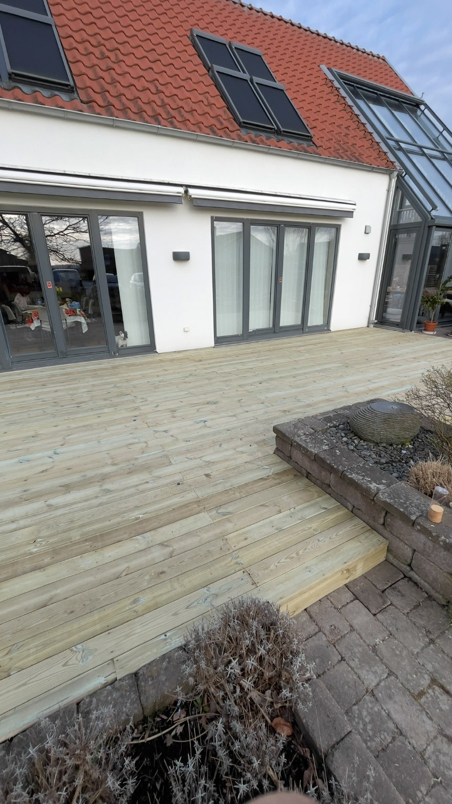 Nytt trädäck framför villa med glasveranda